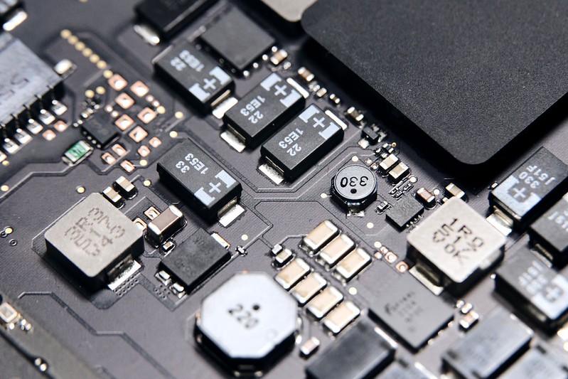 A photo of a semiconductor. There are lots of small metalic and plastic elements in a square.